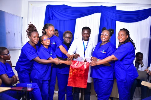 Students and faculty posing with a gift